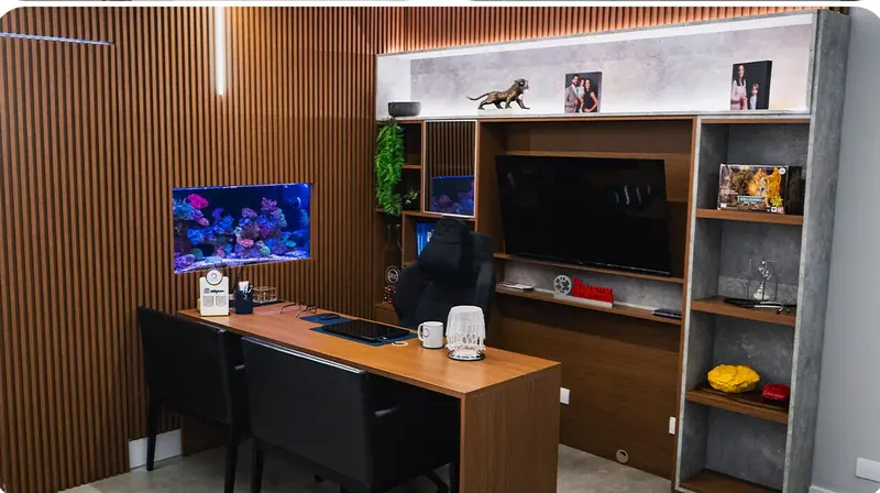 Consultório da Clínica O3, com mesa de atendimento, painel de madeira e aquário